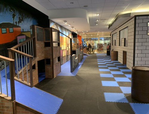 Indoor play area featuring colorful walls, play structures, and a blue tiled floor.