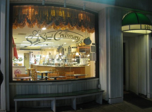 A cozy ice cream shop, South Street Creamery, with a welcoming window display and interior seating.