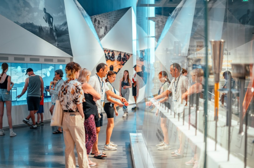 Visitors explore an interactive exhibit in a modern museum, engaging with displays and each other.