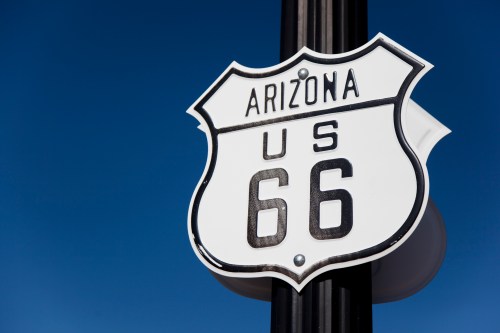 Sign for US Route 66 in Arizona against a clear blue sky.