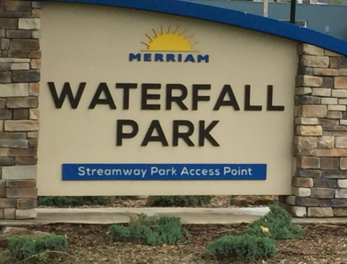 Sign for Waterfall Park, featuring the name and "Streamway Park Access Point," with a stone and blue design.