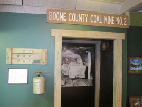 Entrance to Boone County Coal Mine No. 2, featuring a wooden sign and historical mining artifacts on display.
