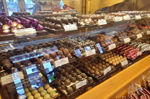 A display case filled with an assortment of colorful chocolates and truffles in various shapes and sizes.