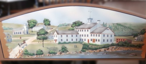 A painted landscape featuring a historic building by a river, surrounded by trees and distant hills.