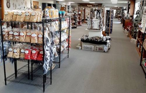A spacious store aisle lined with shelves of snacks and various merchandise, featuring a bright, inviting atmosphere.
