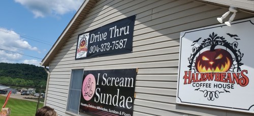 Signage on a building featuring a drive-thru, I Scream Sundae, and Halowbeans Coffee House in Ripley, WV.