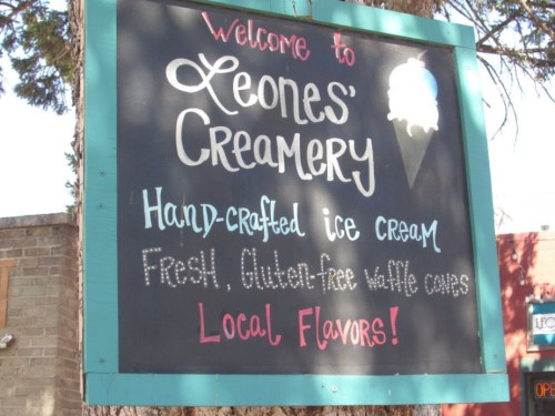 Sign for Leone's Creamery welcoming visitors, featuring hand-crafted ice cream and gluten-free waffle cones. Local flavors!