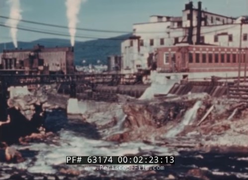 Industrial landscape with factories, smoke stacks, and a river with flowing water, showcasing environmental impact.