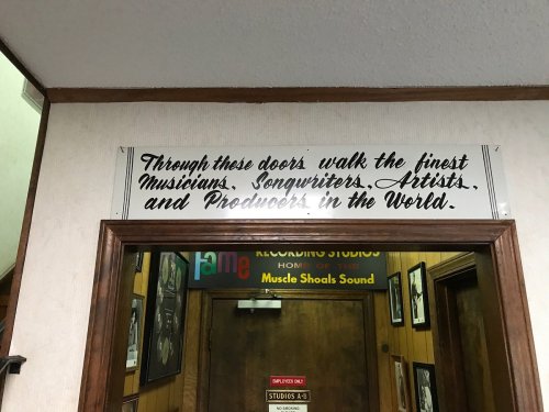 Sign above a doorway reads: "Through these doors walk the finest Musicians, Songwriters, Artists, and Producers in the World."