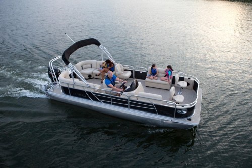 A group of people enjoying a leisurely ride on a pontoon boat on calm water.