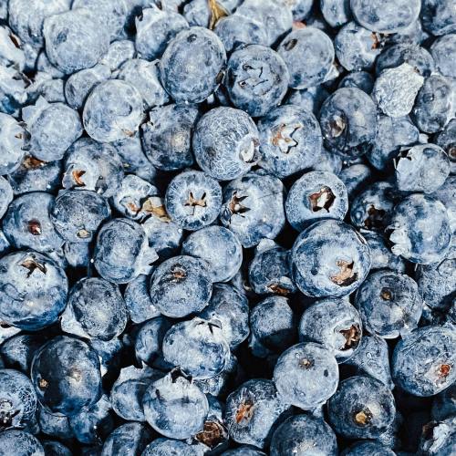 A close-up of fresh, plump blueberries scattered on a surface.