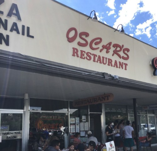 Sign for Oscar's Restaurant with outdoor seating and a clear blue sky in the background.