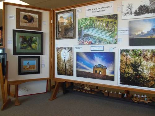 Display of framed photographs at the 2016 Kansas Originals Photo Show, featuring various landscapes and scenes.