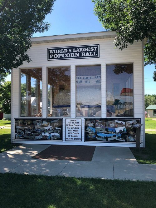 A small building displaying the "World's Largest Popcorn Ball" with photos and information about its size and weight.