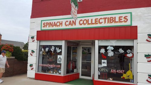 Storefront of "Spinach Can Collectibles" featuring cartoon characters and a bright red and white exterior.