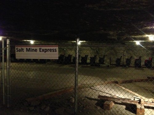 Interior of a salt mine featuring a fenced area with empty chairs and a sign reading "Salt Mine Express."