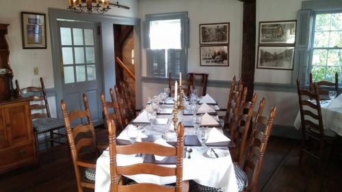 A dining room set for a meal, featuring a long table with chairs, white tablecloth, and elegant place settings.