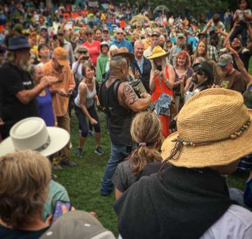 A lively crowd at an outdoor event, with people enjoying music and interacting in a vibrant atmosphere.