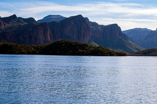 Scenic view of mountains reflecting in a calm lake under a clear blue sky.