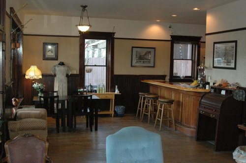 Cozy interior of a vintage-style café with wooden bar, seating area, and decorative lighting.