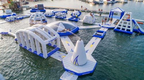 A large inflatable water park with various structures and people enjoying activities on the water.