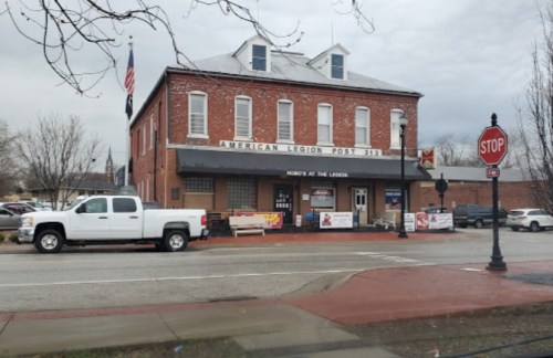 Exterior of the American Legion Post 171 building, featuring a white truck parked outside and a stop sign nearby.