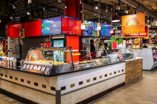 A vibrant food stall with colorful menus and displays, showcasing various dishes in a bustling market setting.