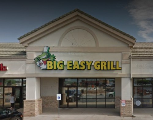 Exterior of Big Easy Grill restaurant with a green frog logo and large yellow signage.