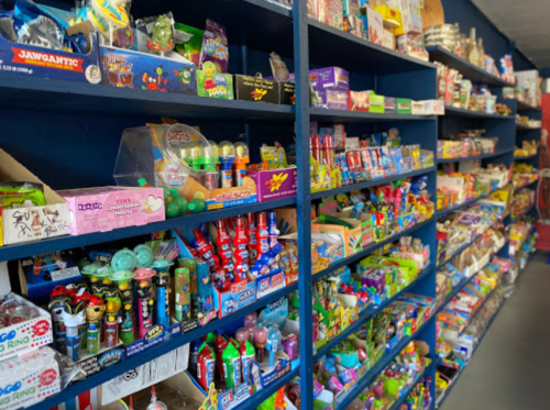 A colorful display of various candies and snacks on shelves in a store.