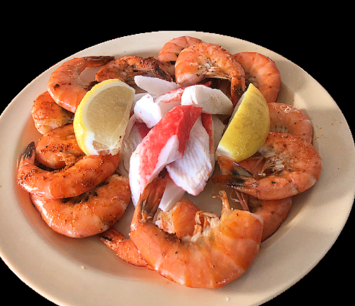 A plate of cooked shrimp garnished with lemon wedges and crab meat in the center.
