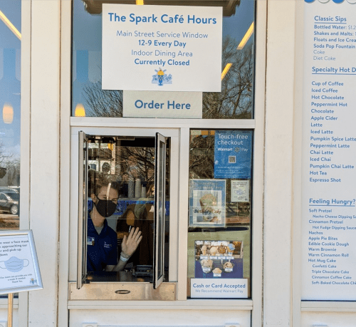 A service window at Spark Café displays hours and a sign indicating the indoor dining area is closed.