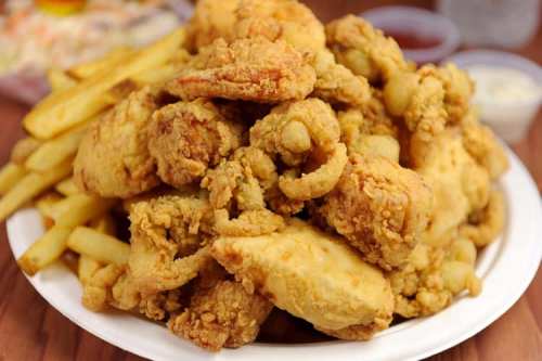 A plate piled high with crispy fried chicken and golden French fries.