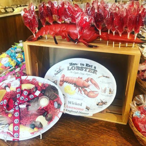 A display featuring a large lobster, candy lollipops, and a sign on how to eat lobster with a dinner plate illustration.