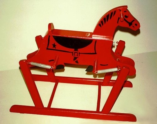 A vintage red rocking horse with black details, featuring a saddle and a sturdy wooden base.