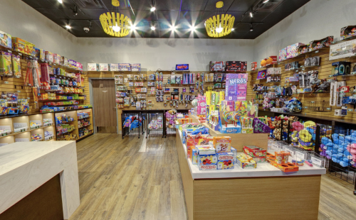 A colorful candy store interior filled with various snacks and treats on shelves and displays.