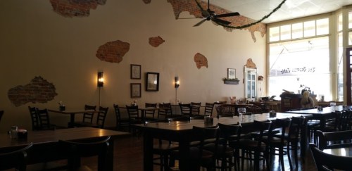 Interior of a rustic restaurant with exposed brick walls, wooden tables, and a cozy atmosphere.