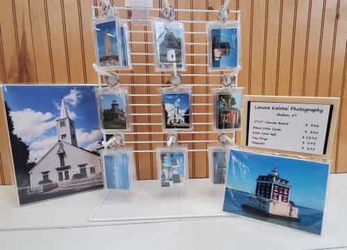 Display of photographs featuring lighthouses, with pricing information for prints and postcards.
