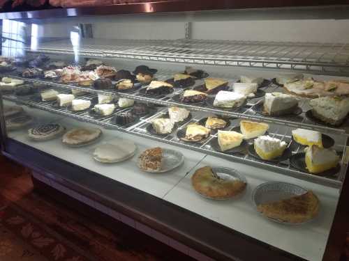 A display case filled with various types of pies and desserts, including cream and fruit varieties.