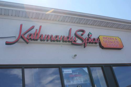 Sign for "Kathmandu Spice" featuring Indian and Nepalese cuisine, displayed on a restaurant exterior.