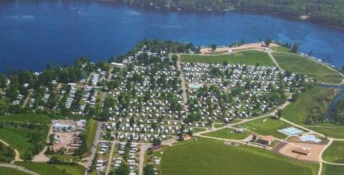 Aerial view of a lakeside community with numerous homes, green spaces, and recreational areas along the water.
