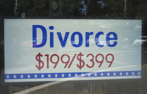 Sign in a window advertising divorce services for $199 and $399, with a blue and red color scheme.