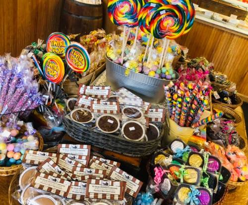 A colorful display of various candies, including lollipops, chocolate treats, and vibrant sweets in baskets.