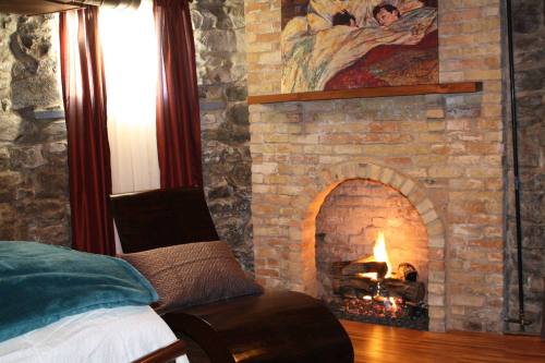Cozy room with a stone fireplace, wooden furniture, and a painting above the mantel, creating a warm atmosphere.