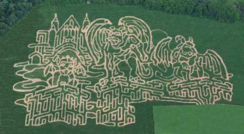 Aerial view of a corn maze featuring whimsical characters and structures carved into a green field.