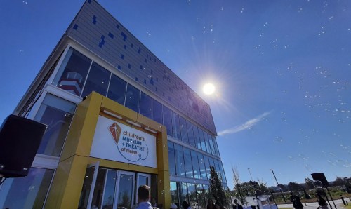 Bright sun shines over the Children's Museum and Theatre of Maine, showcasing its modern architecture and outdoor space.
