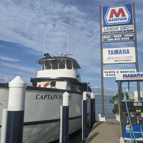 A boat named "Captain P" docked near a sign for Marathon with services for bait, beer, food, and boat parts.