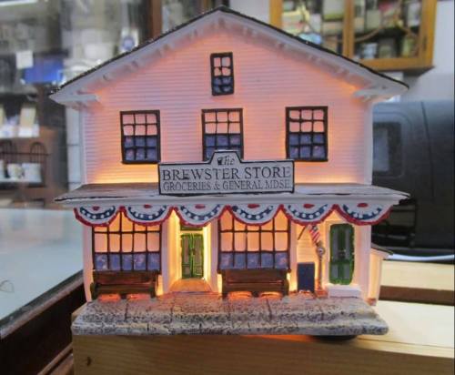 A miniature model of the Brewster Store, illuminated with decorative bunting and a welcoming facade.