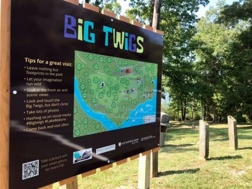 Signboard titled "Big Twigs" with tips for visitors, featuring a map and nature-themed graphics in a park setting.