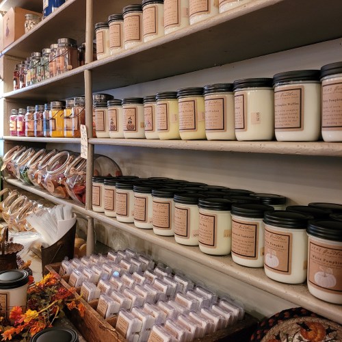 Shelves filled with various jars of candles and colorful jars, creating a cozy, inviting atmosphere.