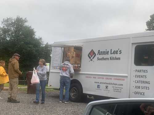 A food truck named "Annie Lee's Southern Kitchen" with customers ordering and waiting for food in a casual outdoor setting.